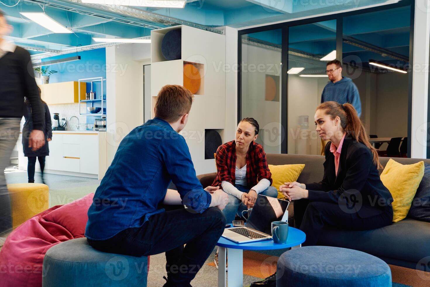 Multiethnic startup business team on meeting in a modern bright open space coworking office. Brainstorming, working on laptop. Group of coworkers walking around in motion blur photo