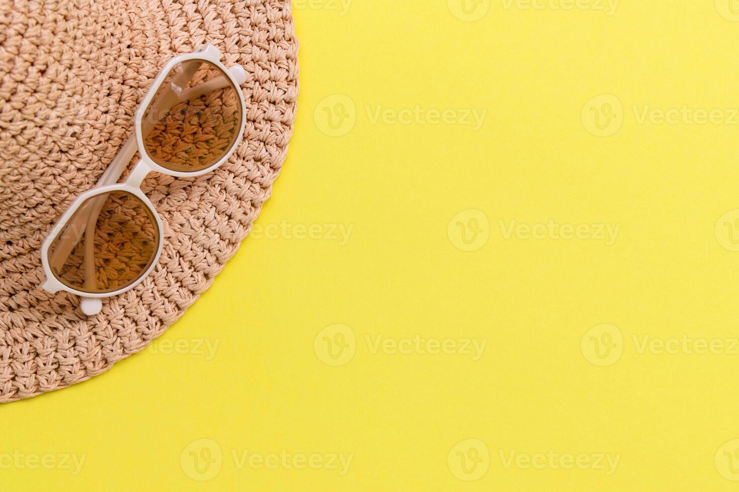 sunglasses and striped retro hat on yellow background. summer vacation concept. photo