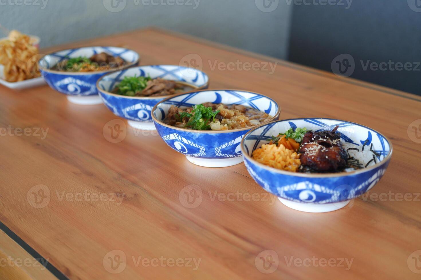 Each bowl contains different ingredients such as meats, vegetables, and rice, garnished with green herbs photo