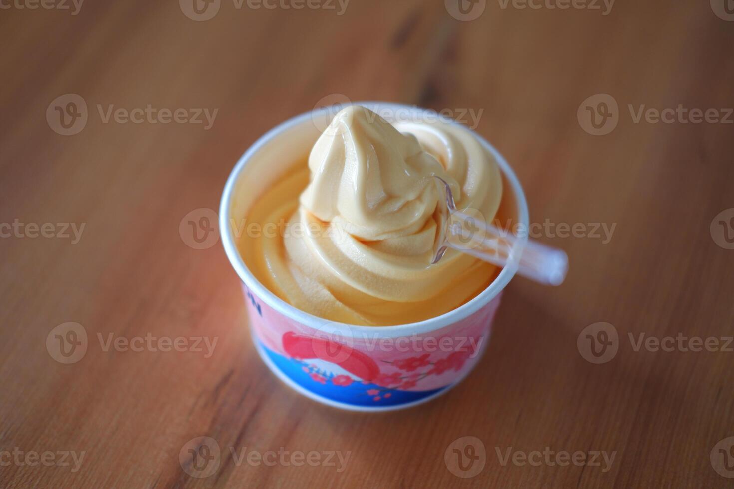 ice cream in paper cup on wood table background. soft focus. photo