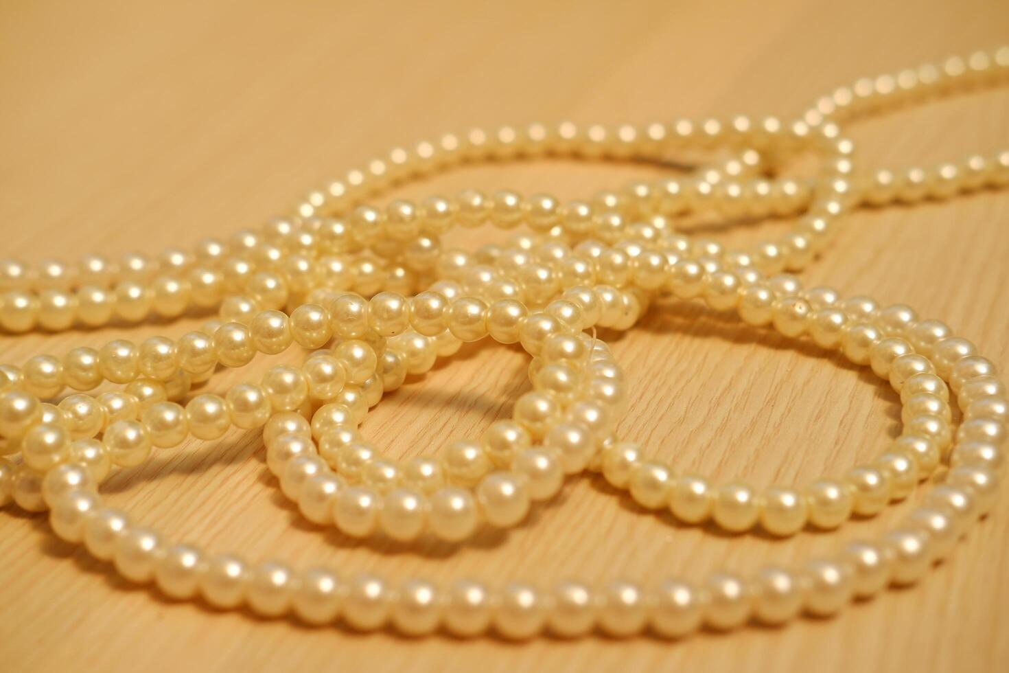 Pearls arranged neatly on a rustic wooden table photo