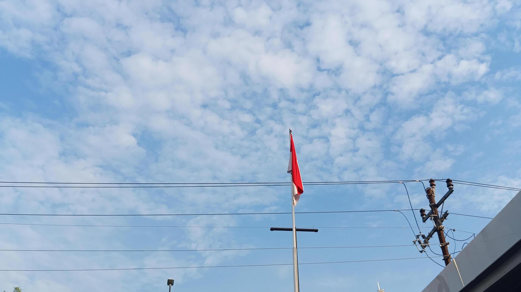 Indonesian flag on pole with blue sky background photo