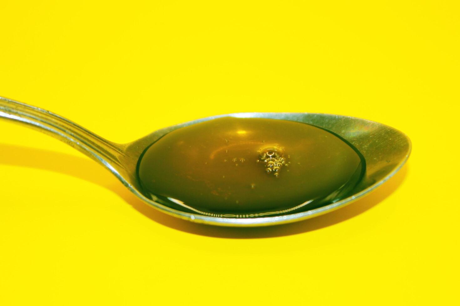 honey in a spoon, honey, honey on a yellow background photo