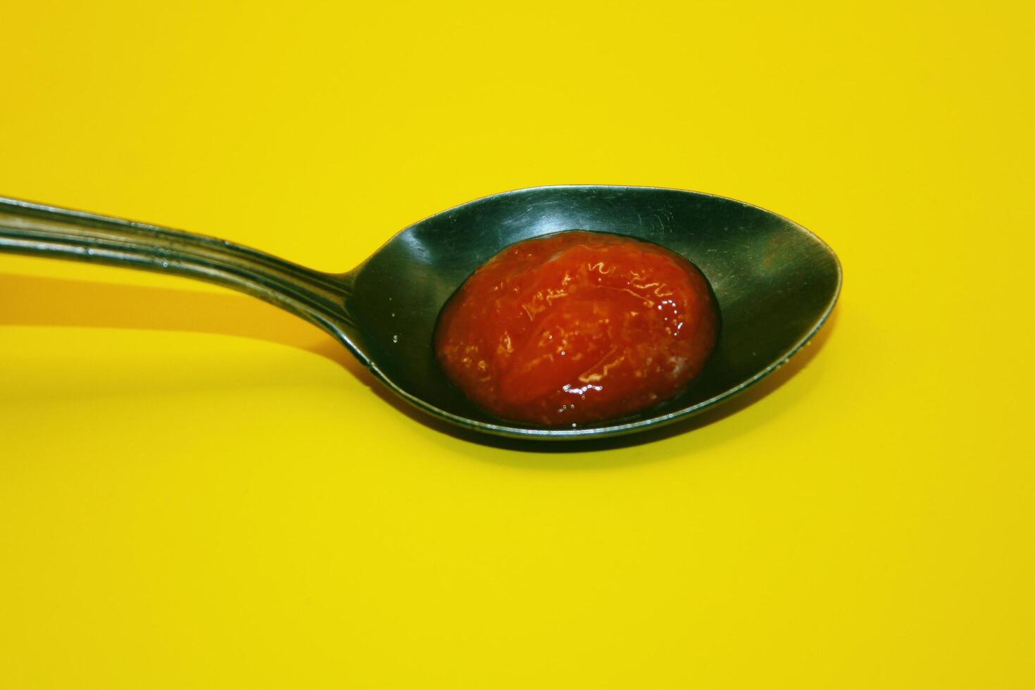 red tomato sauce in spoon, red sauce with yellow color lat photo