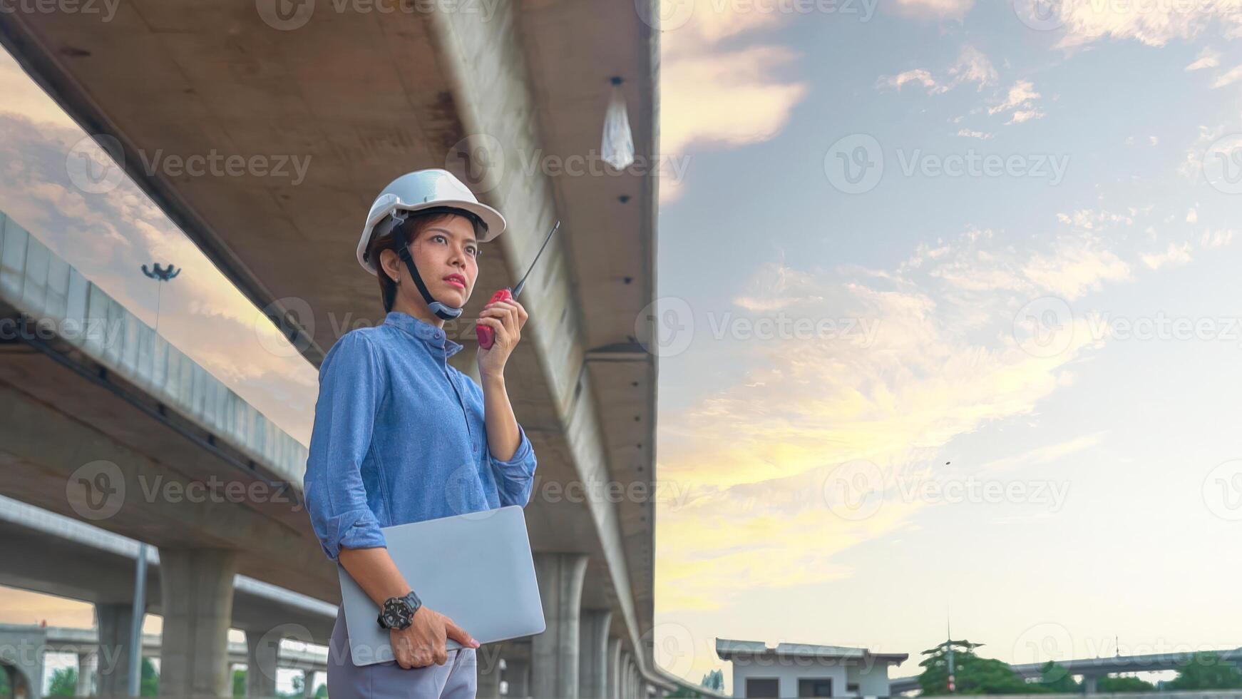Asian female team leader wearing white safety fog Radio commands are being used in places, concrete roads, highway bridges. photo