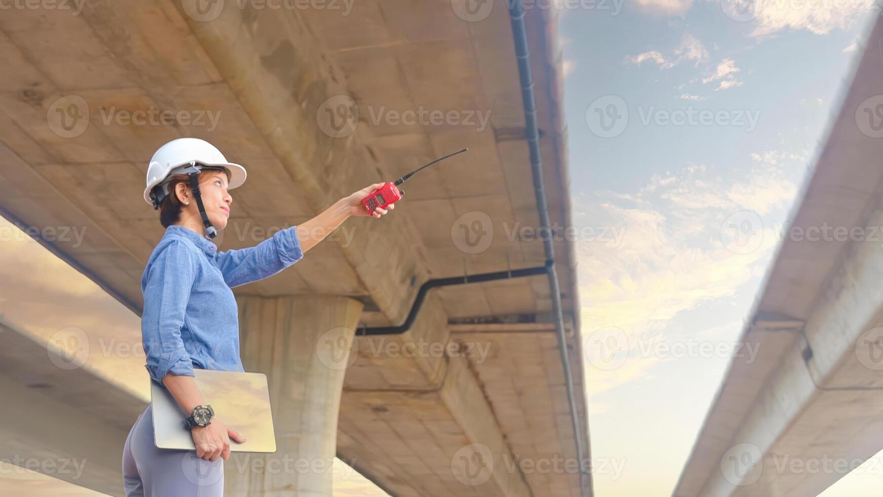 Asian female team leader wearing white safety fog Radio commands are being used in places, concrete roads, highway bridges. photo