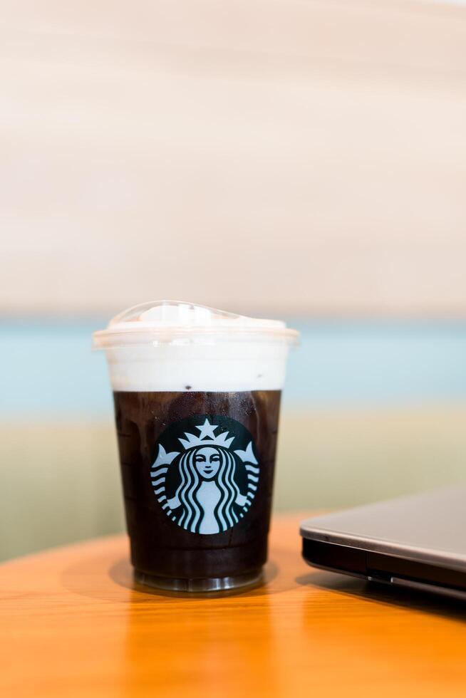 Bangkok, Thailand - June 24, 2024 Starbucks cold brew beverage cup on wood table at Starbucks shop photo