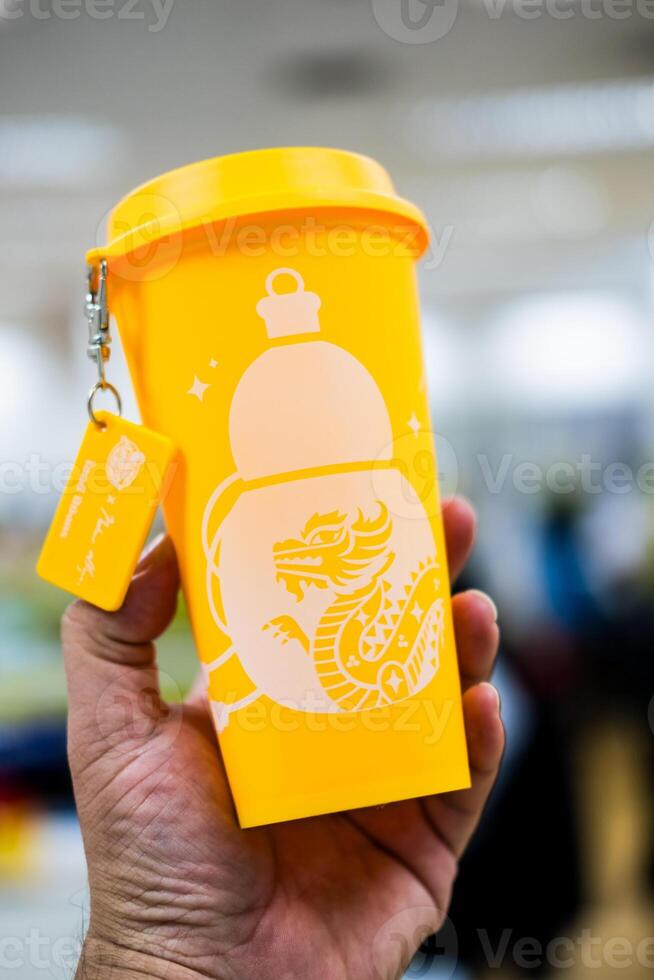 Bangkok, Thailand - June 25, 2024 A yellow reusable cup from Cafe Amazon, Get power to enhance your luck with cup name of Dragon pattern. Get 1 free Dragon Reusable Cup in June 25, 2024 photo