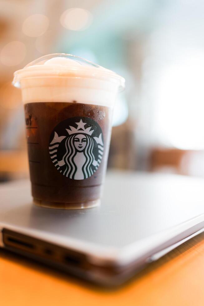Bangkok, Thailand - June 23, 2024 Starbucks cold brew beverage cup on wood table at Starbucks shop photo