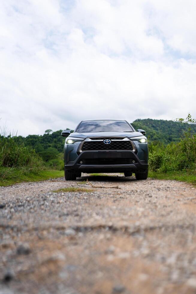 Bangkok, Thailand - June 23, 2024 Private new Toyota corolla CROSS, Celestite gray metallic parked in the middle of nature, forest and mountains photo