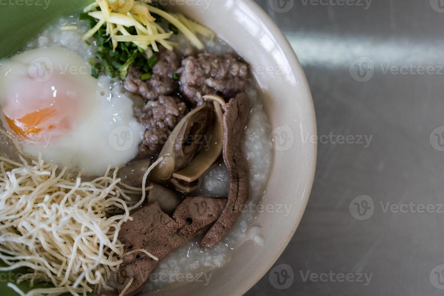 Congee with minced pork, liver, pork entrails and boiled egg in a bowl photo