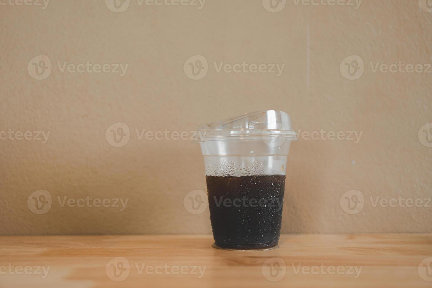 A plastic glass that was almost empty left Americano coffee and no ice photo