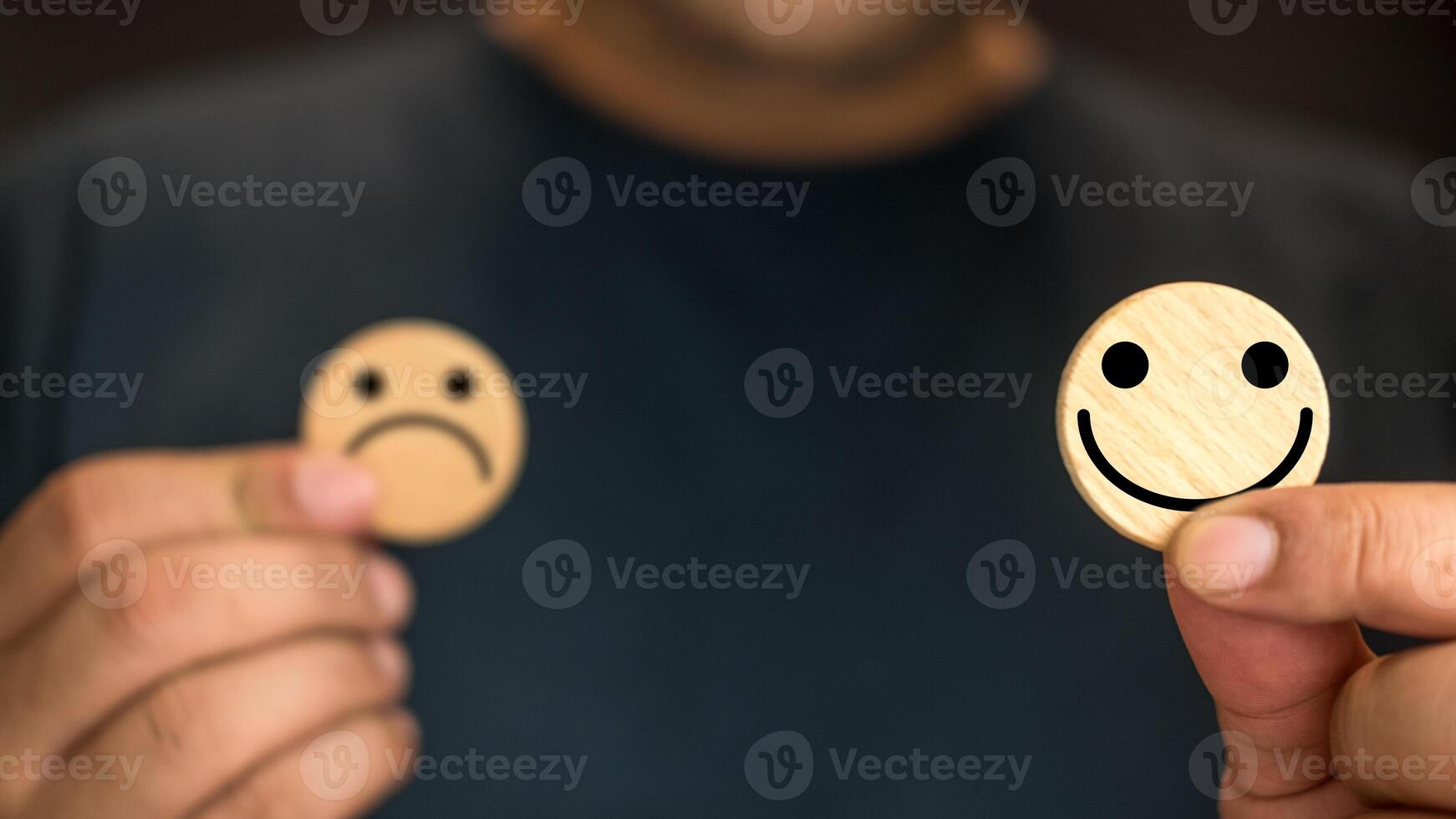 Man choice a happy smile face in wood circle block for a positive mindset selection. photo