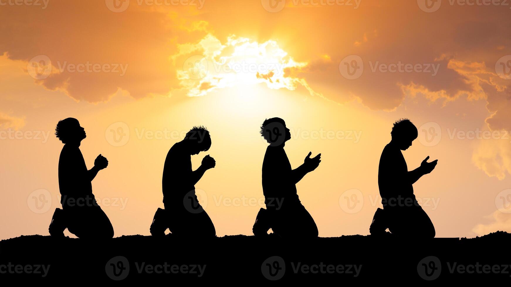 Silhouetted Figures Praying at Sunset with Dramatic Sky and Sunlight in the Background, Capturing Spirituality, Devotion, and Peaceful Reflection in a Serene Outdoor Setting photo