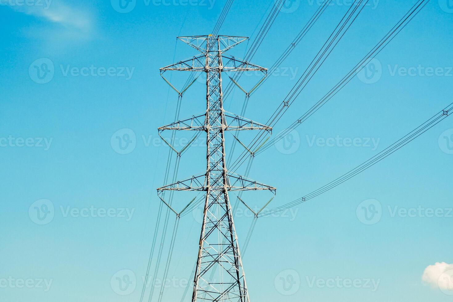 High Voltage Power Line Tower Against Clear Blue Sky - Energy Infrastructure and Electricity Transmission Concept photo