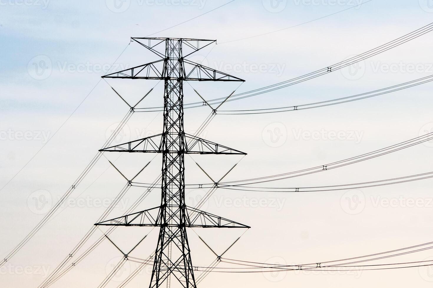 High Voltage Power Line Tower Against a Clear Sky at Dusk - Industrial Infrastructure and Energy Transmission Concept photo