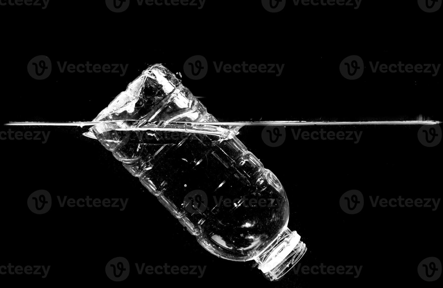 Plastic Bottle Floating in Water Against Black Background Highlighting Environmental Pollution and Waste Management Issues photo