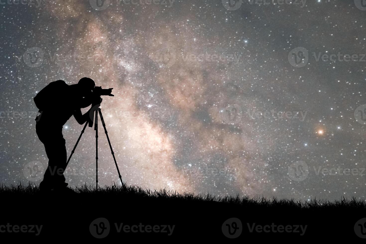 Silhouette of a Photographer Capturing the Night Sky with the Milky Way in the Background photo