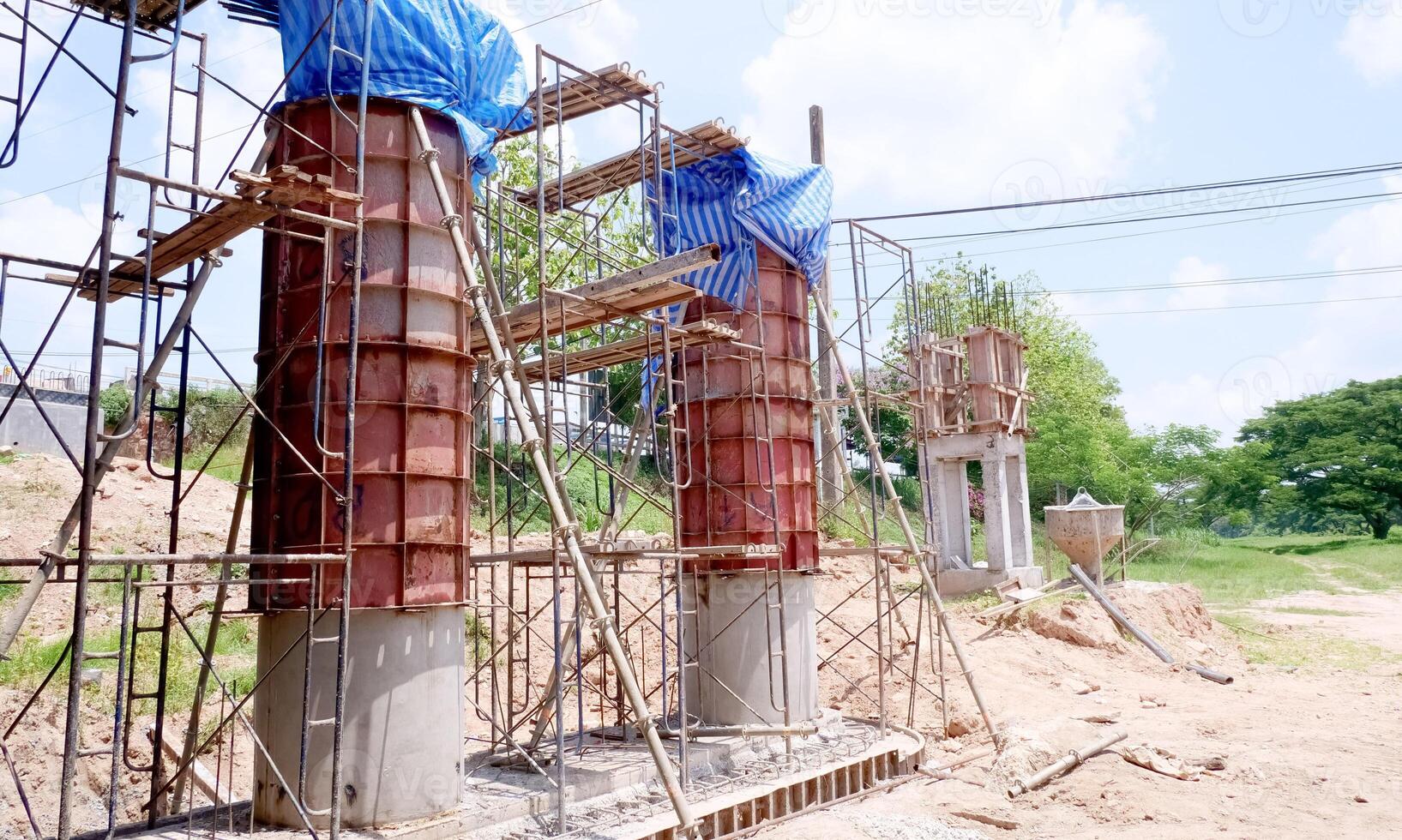 Construction Site with Concrete Columns and Scaffolding Under Blue Sky - Infrastructure Development and Building Progress in a Rural Area photo