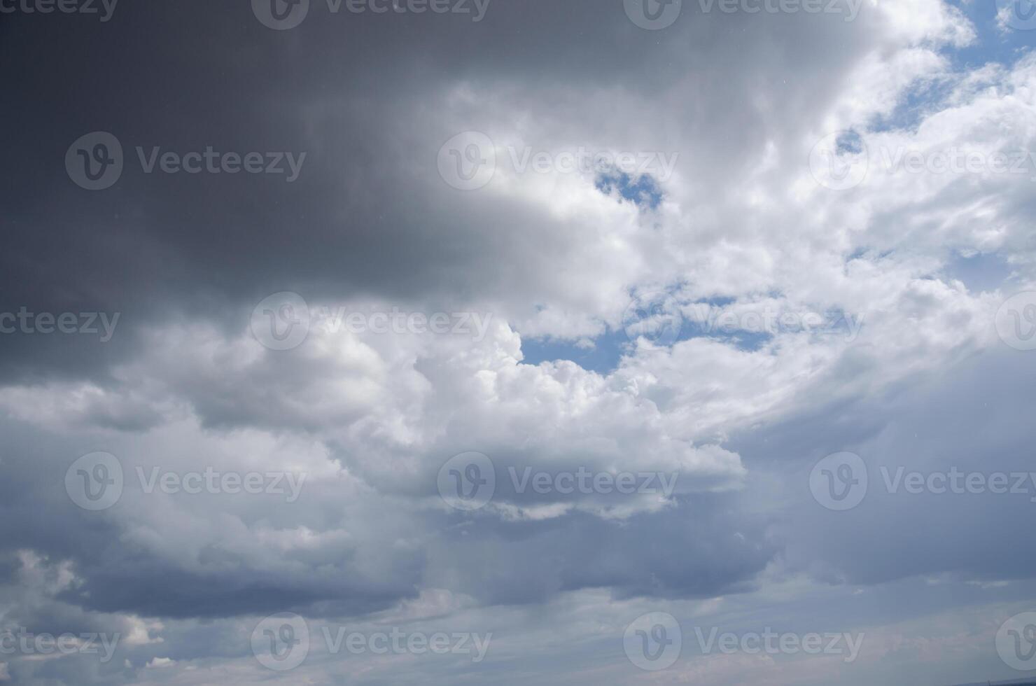 dark clouds with a gap of blue sky and white clouds. High quality photo