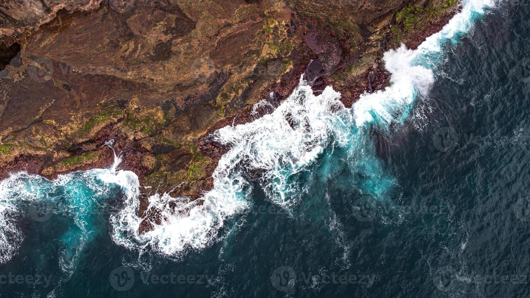 Stunning drone shots of Little Blowhole, Kiama, capturing the intricate rock formations and dynamic waves from a top-down view. Perfect for showcasing Australia's coastal beauty and natural wonders. photo