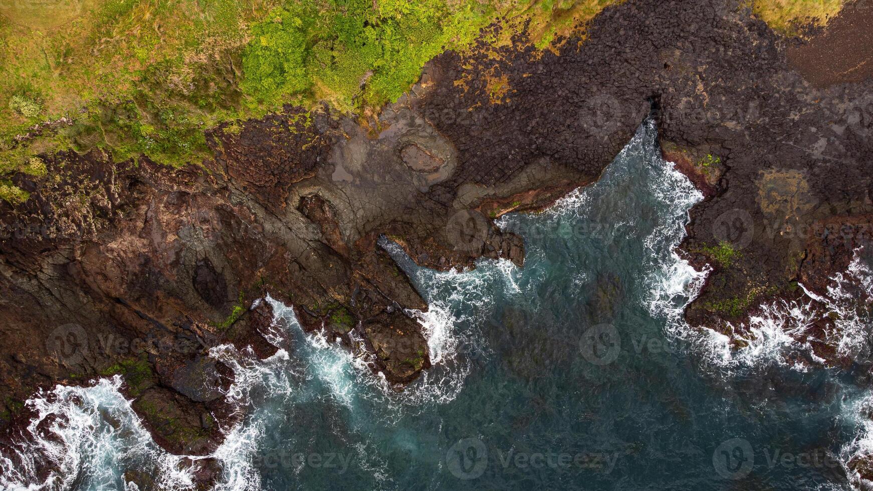 Stunning drone shots of Little Blowhole, Kiama, capturing the intricate rock formations and dynamic waves from a top-down view. Perfect for showcasing Australia's coastal beauty and natural wonders. photo