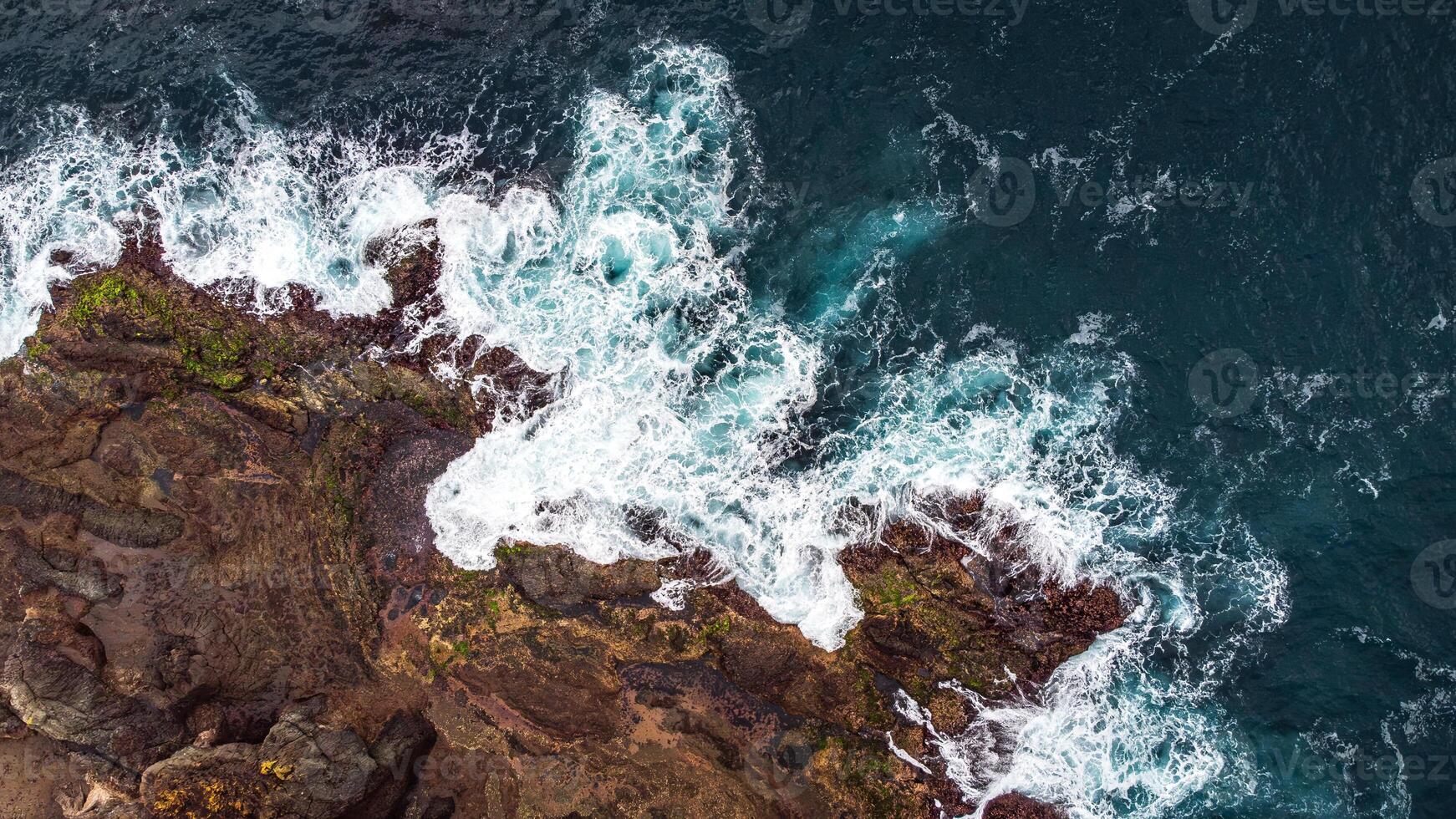 Stunning drone shots of Little Blowhole, Kiama, capturing the intricate rock formations and dynamic waves from a top-down view. Perfect for showcasing Australia's coastal beauty and natural wonders. photo