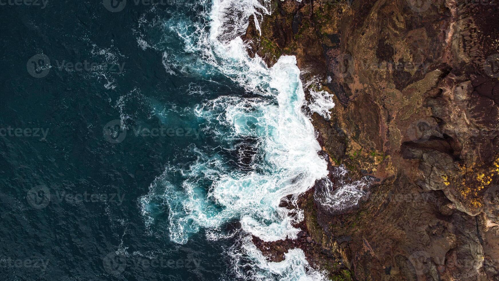 Stunning drone shots of Little Blowhole, Kiama, capturing the intricate rock formations and dynamic waves from a top-down view. Perfect for showcasing Australia's coastal beauty and natural wonders. photo