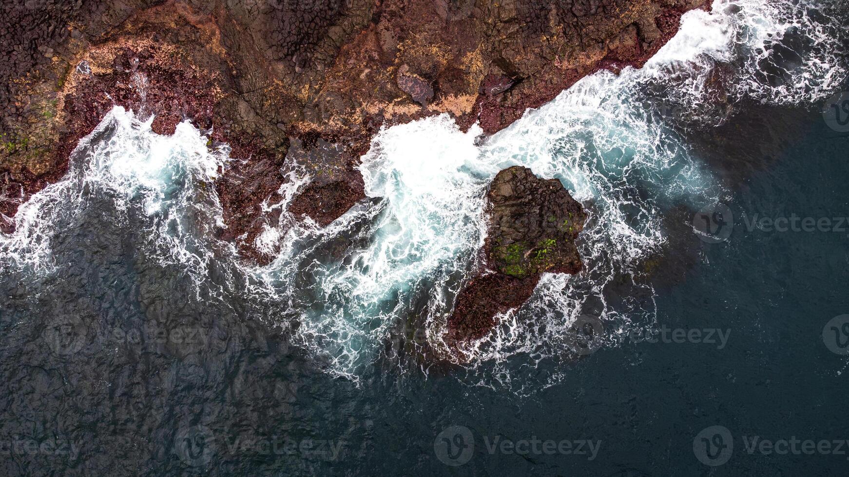 Stunning drone shots of Little Blowhole, Kiama, capturing the intricate rock formations and dynamic waves from a top-down view. Perfect for showcasing Australia's coastal beauty and natural wonders. photo