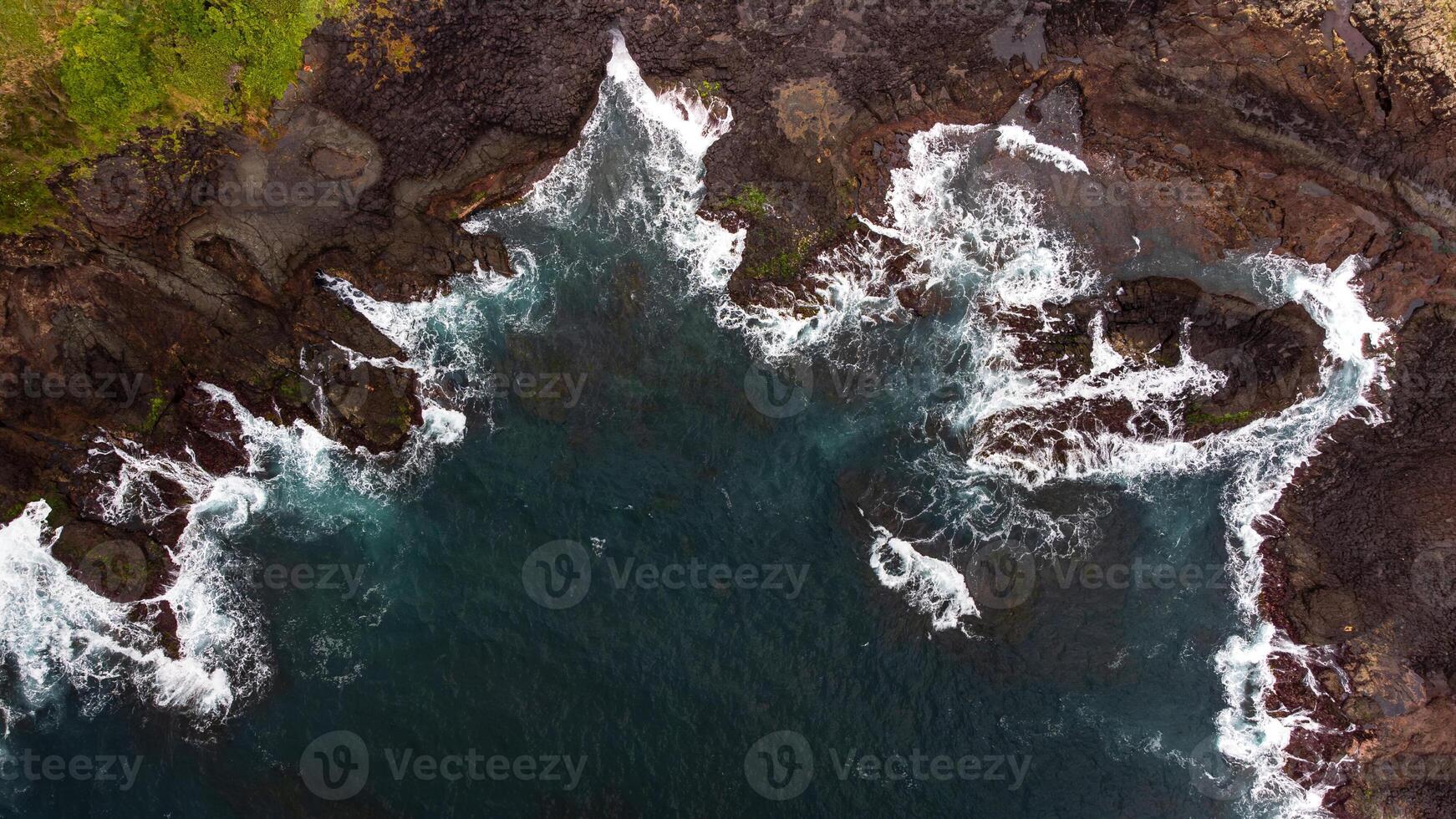 Stunning drone shots of Little Blowhole, Kiama, capturing the intricate rock formations and dynamic waves from a top-down view. Perfect for showcasing Australia's coastal beauty and natural wonders. photo