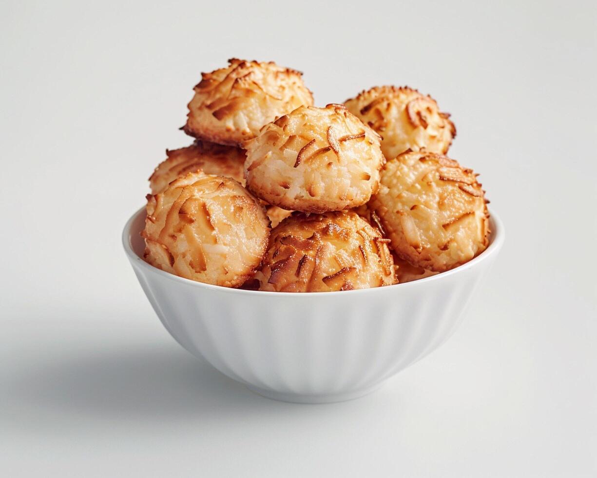 a bowl of baked cookies on a white surface photo