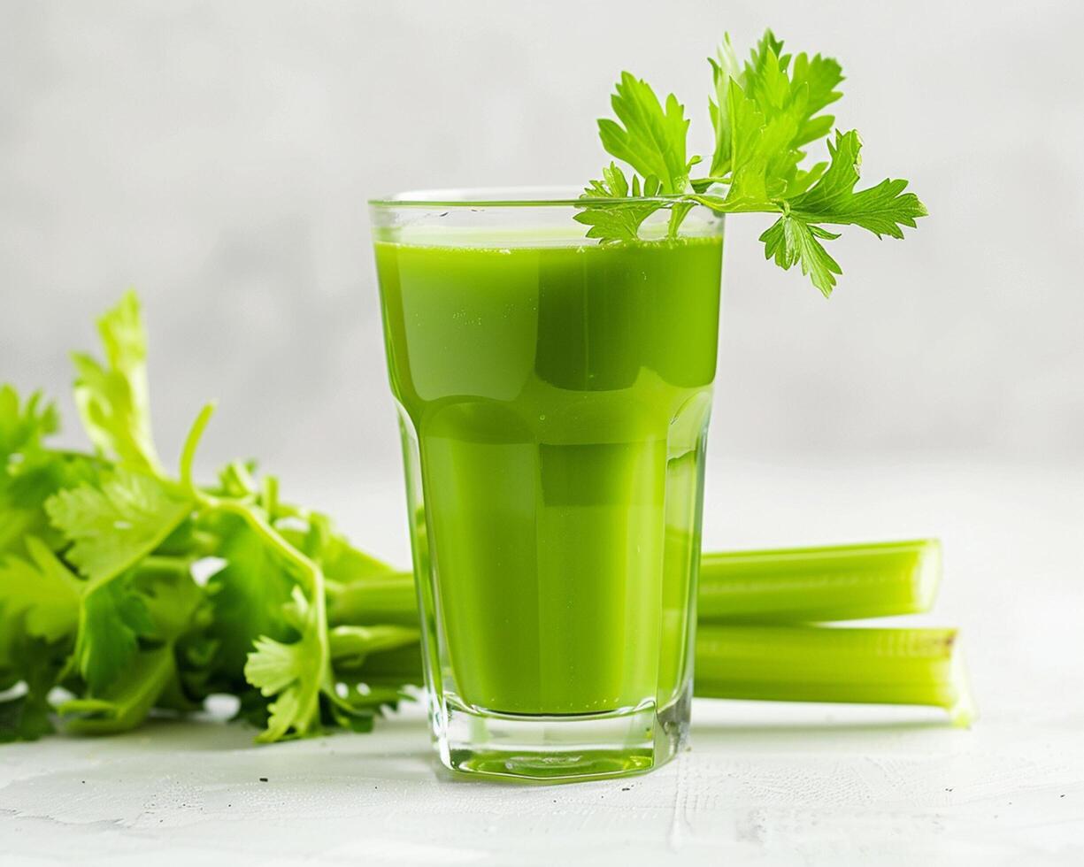 a glass of green juice with celery and parsley photo