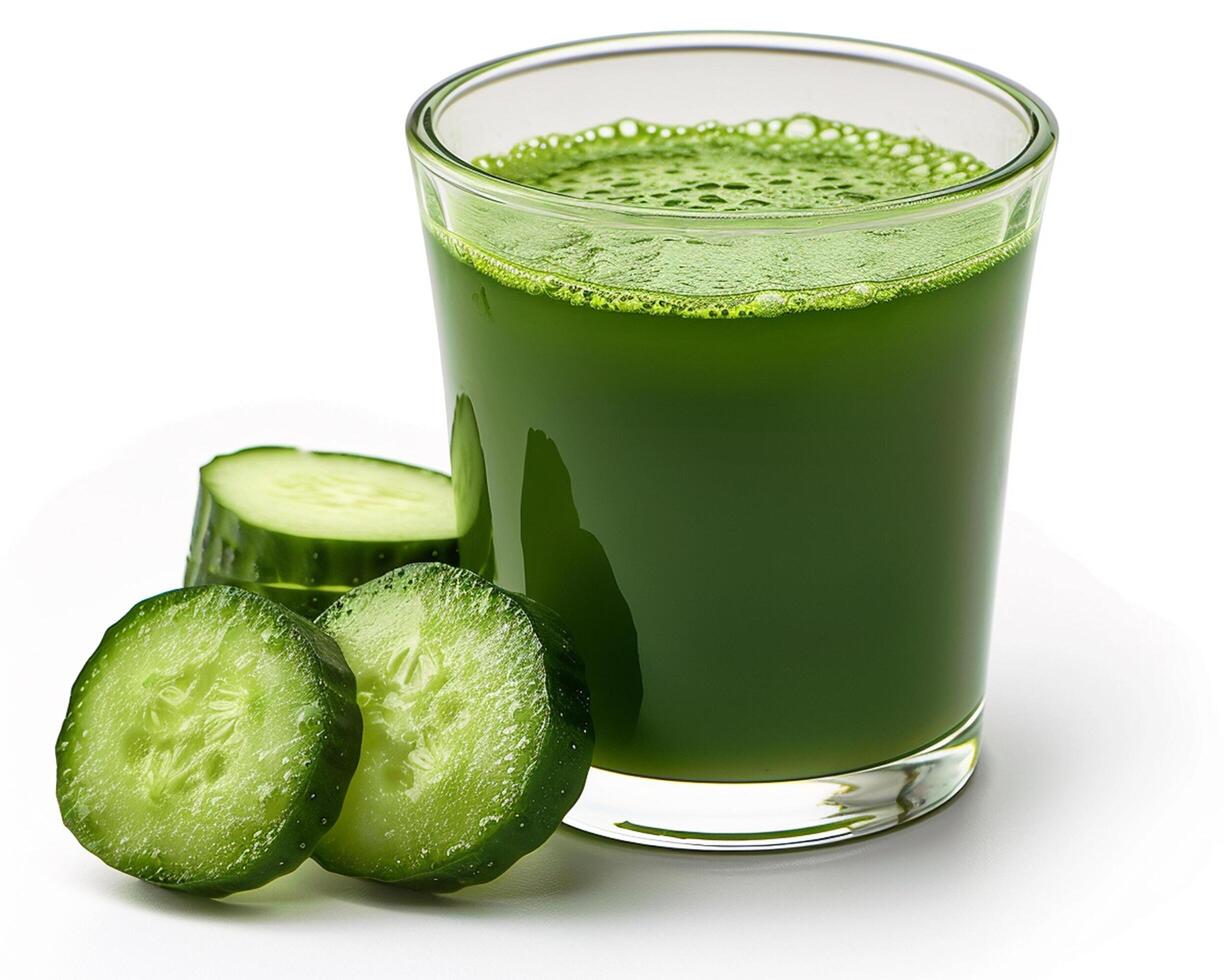 a glass of green juice next to a slice of cucumber photo