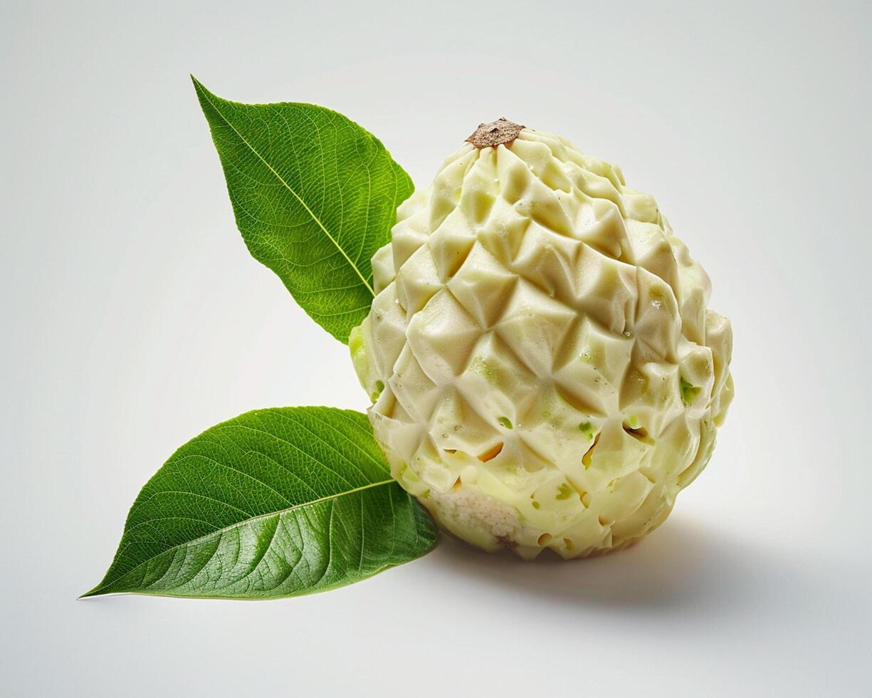 a white fruit with green leaves on it photo