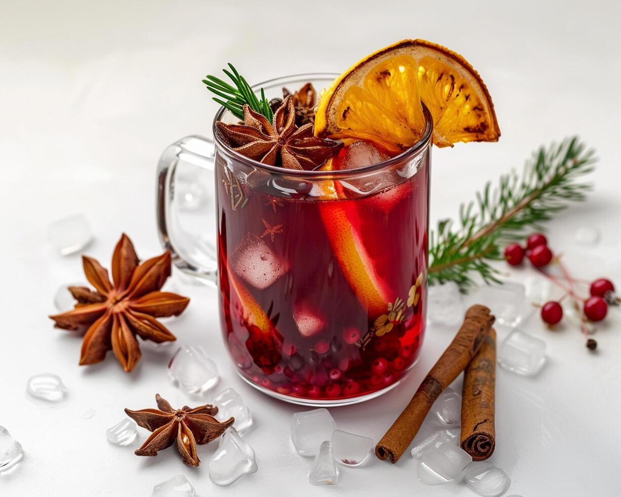 a glass of mulled wine with cinnamon, an orange and an anise photo