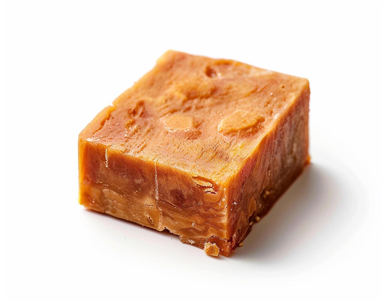 a piece of orange soap on a white surface photo