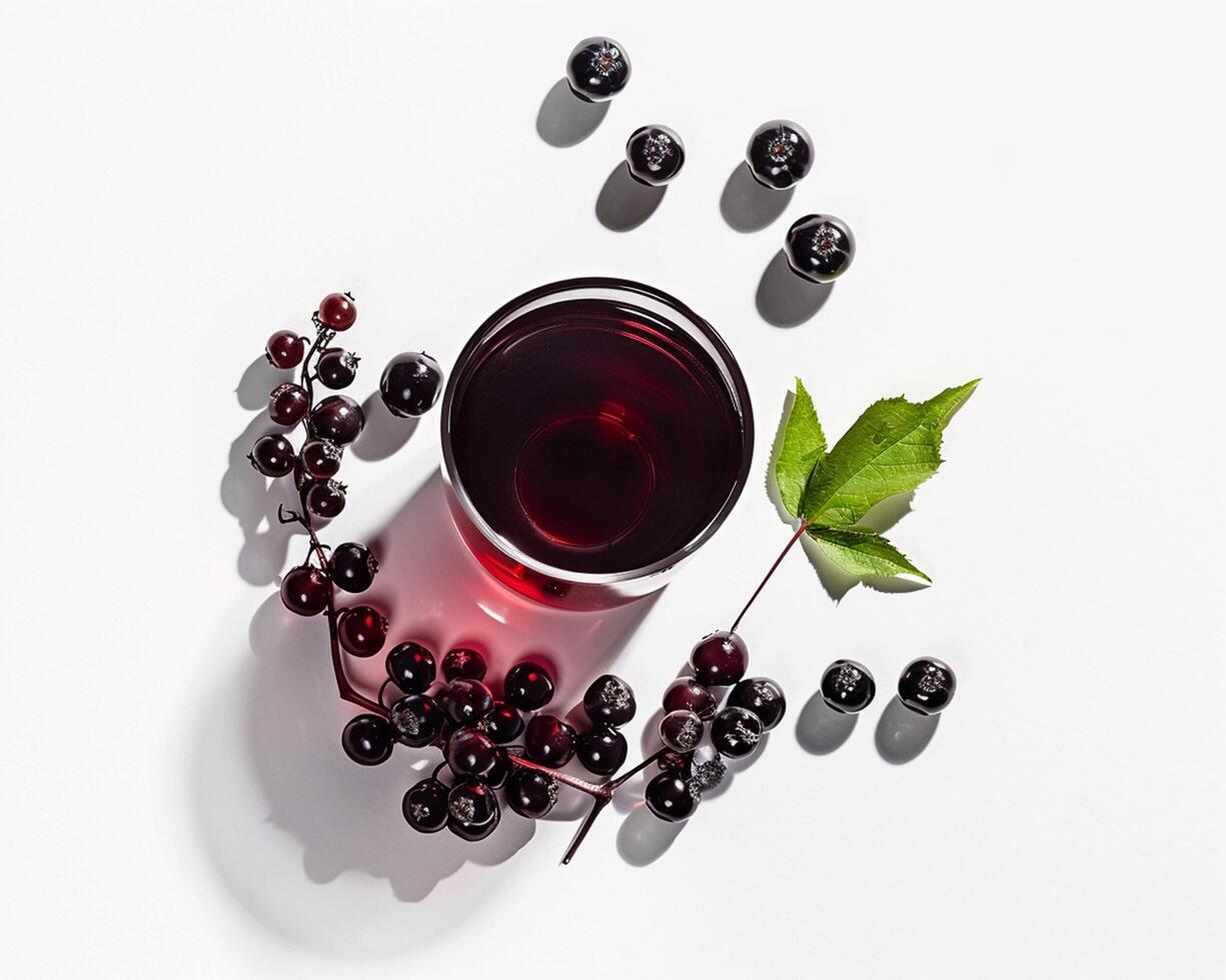 a glass of black currant with berries on a white surface photo