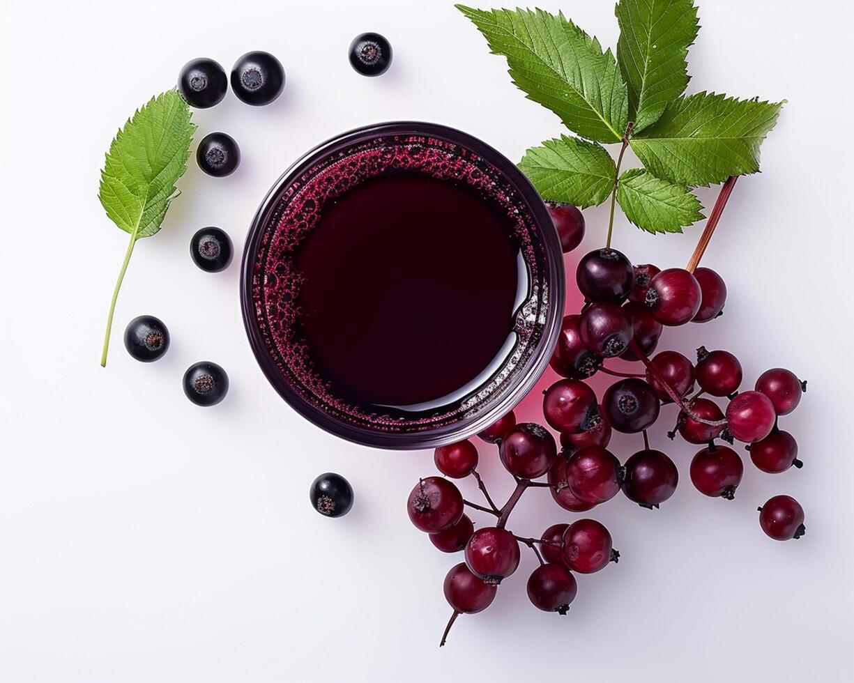 black currant juice with black currant leaves and berries on white background photo