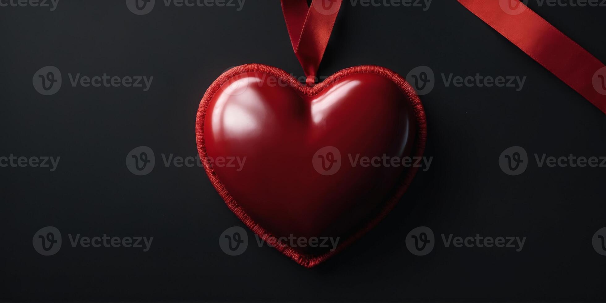 A bright red heart with a red ribbon on a black background with an empty space, banner. photo