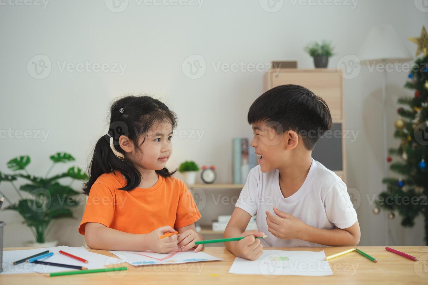 Asian little girl is sitting on a green slide at a playground. The playground is full of colorful equipment and the girl is wearing a purple shirt photo