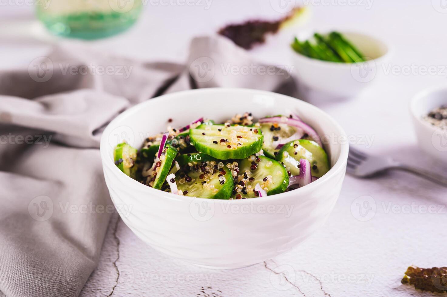 Vegetarian salad of quinoa, cucumber and red onion in a bowl on the table photo