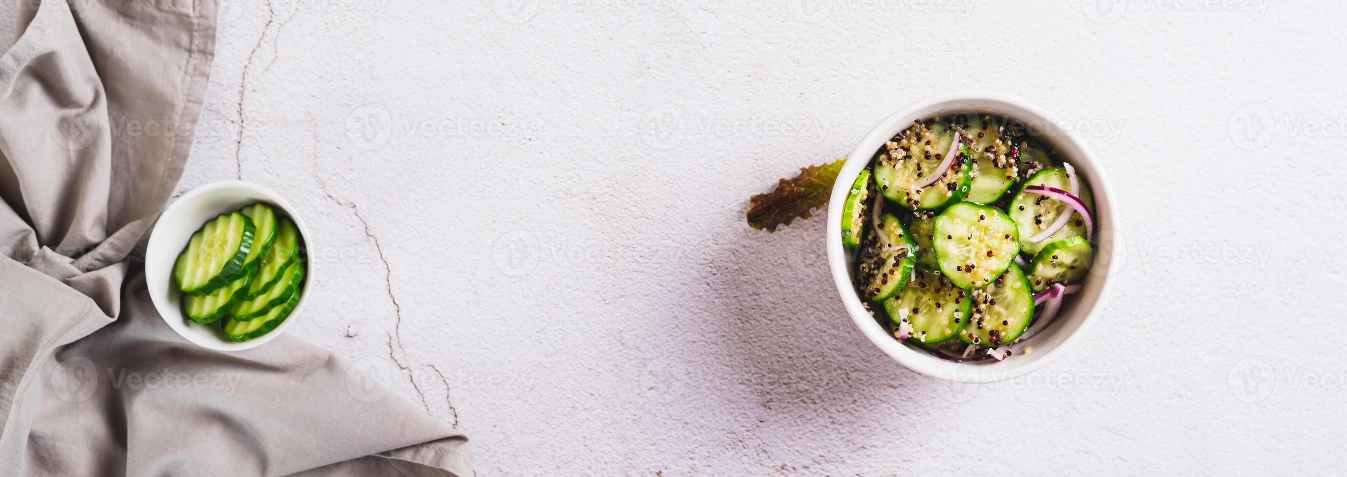 Healthy organic cucumber, quinoa and onion salad in a bowl on the table top view web banner photo