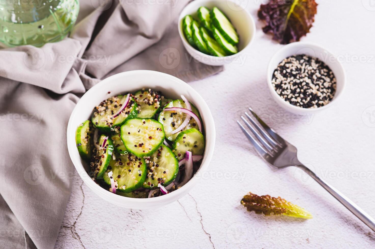 Healthy organic cucumber, quinoa and onion salad in a bowl on the table photo