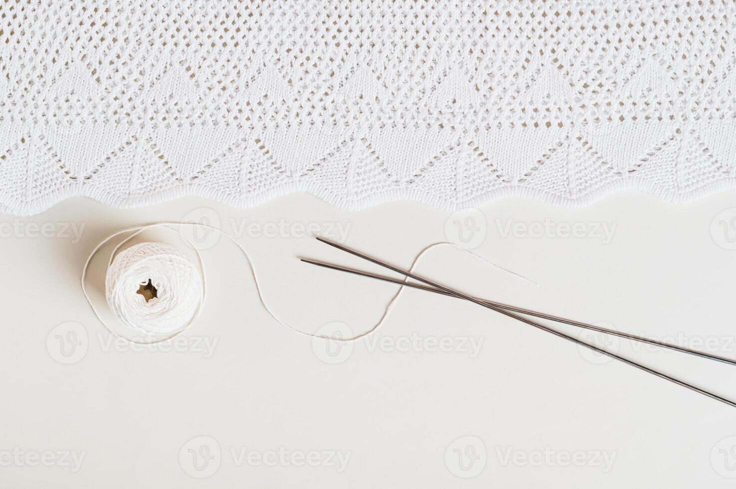 Knitting background, finished texture, ball and knitting needles on a light background top view photo