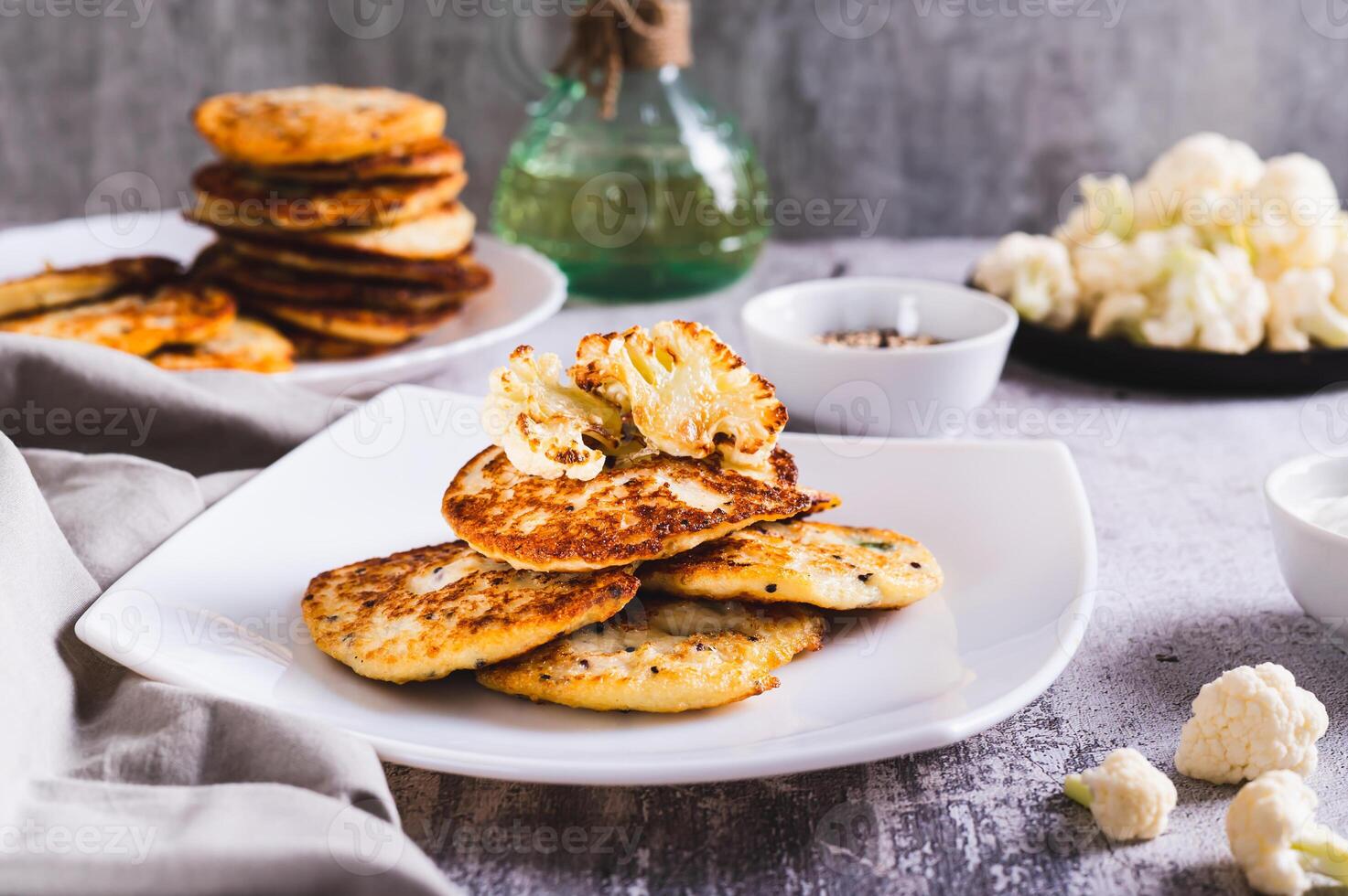 Spicy vegetarian cauliflower fritters on a plate on the table photo