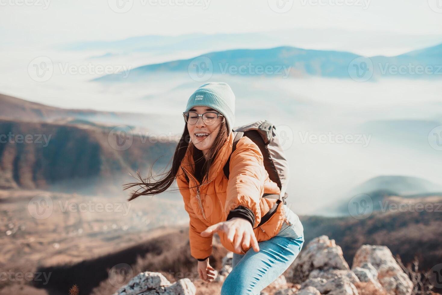 People helping each other hike up a mountain at sunrise. photo