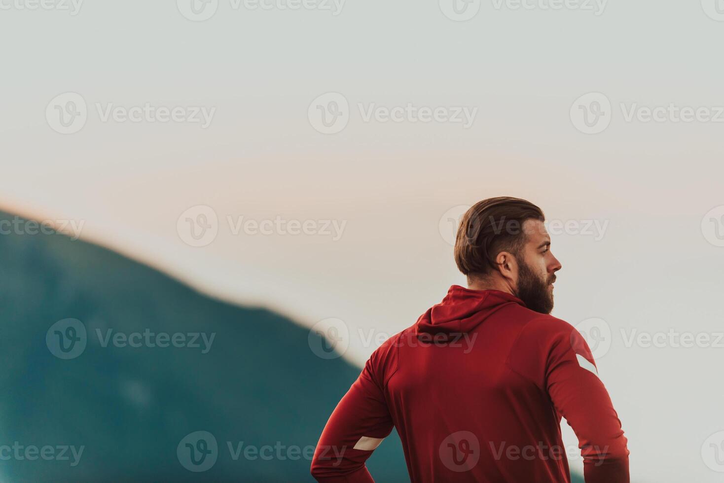 An athlete rests on top of a mountain after exhausting running training. photo