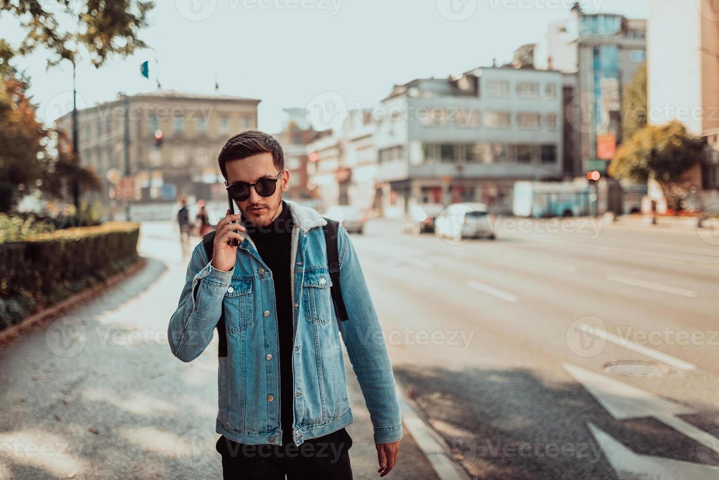 Modern man in sunglasses talking on the smartphone on the street photo