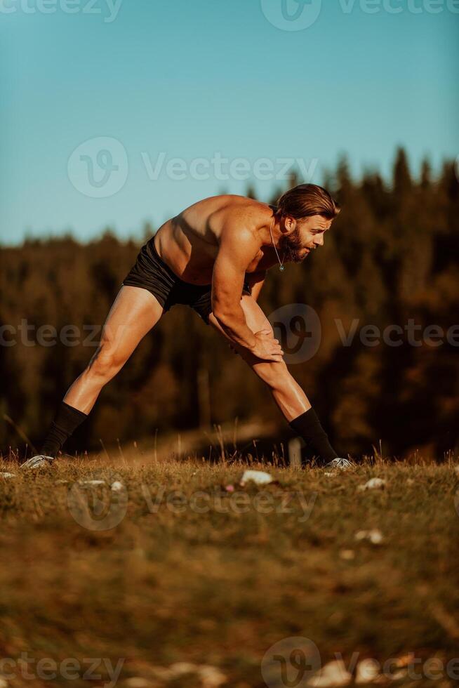 A man stretching after a hard workout in the early hours of the morning photo