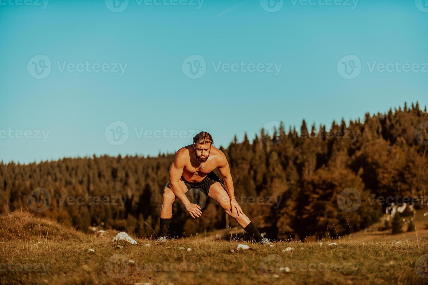 A man stretching after a hard workout in the early hours of the morning photo